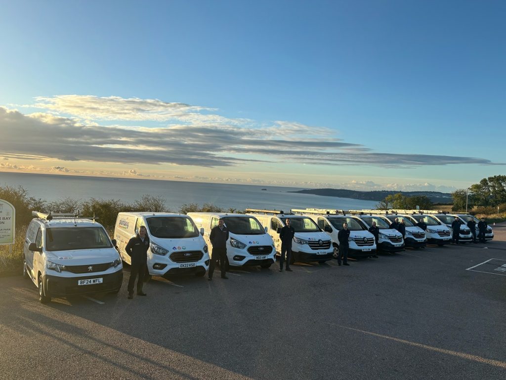 10 vans with 10 plumbers standing above beautiful Torbay lookout.