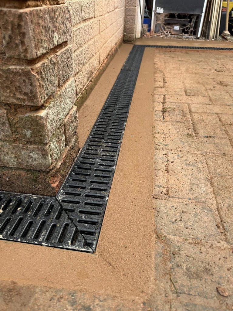 Clean brickwork, patio and drainage at corner of new build house, Exeter