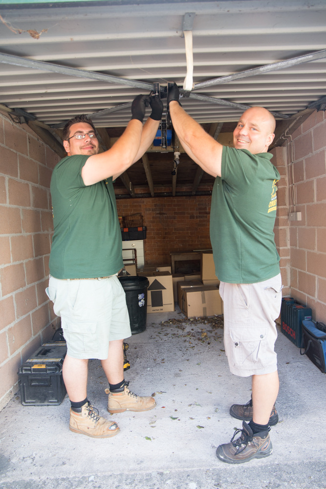 Two friendly looking garage door installers at work