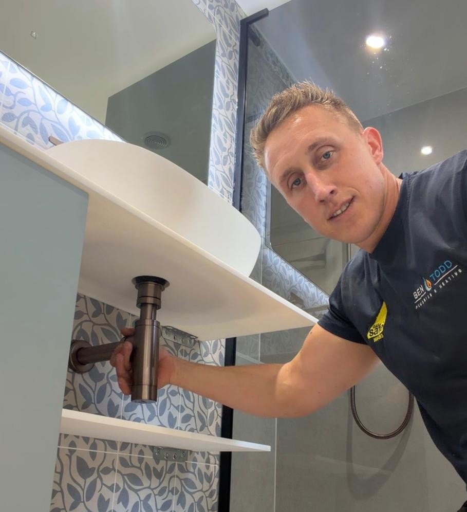 Friendly plumber installing a bathroom sink in Newton Abbot